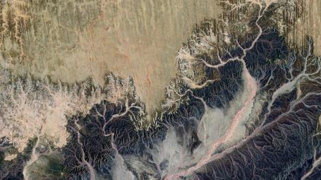 An aerial photograph of a landscape with dry riverbeds