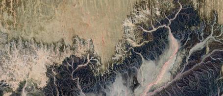 An aerial photograph of a landscape with dry riverbeds